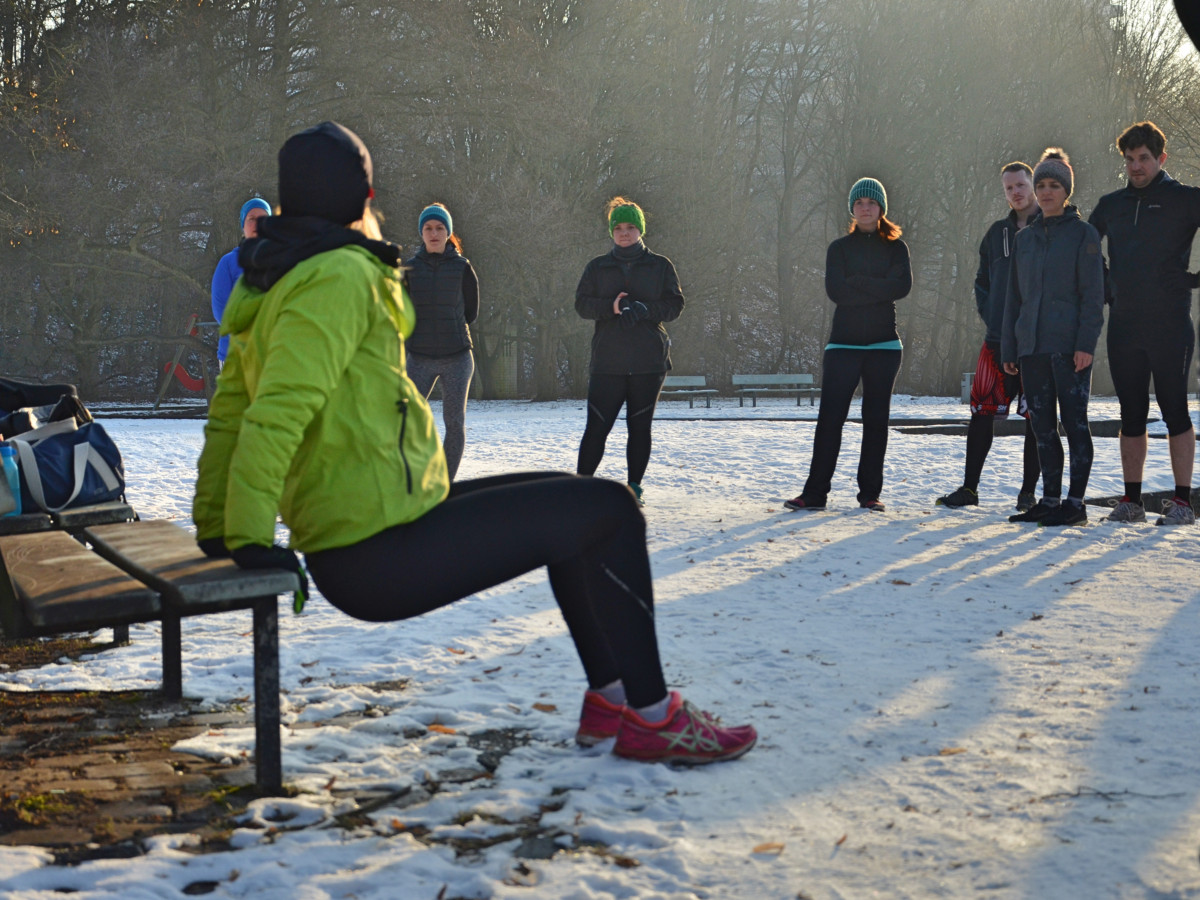 Anleitung durch den Fitness Trainer beim Outdoor Training - Hier bei der Übung Rudern