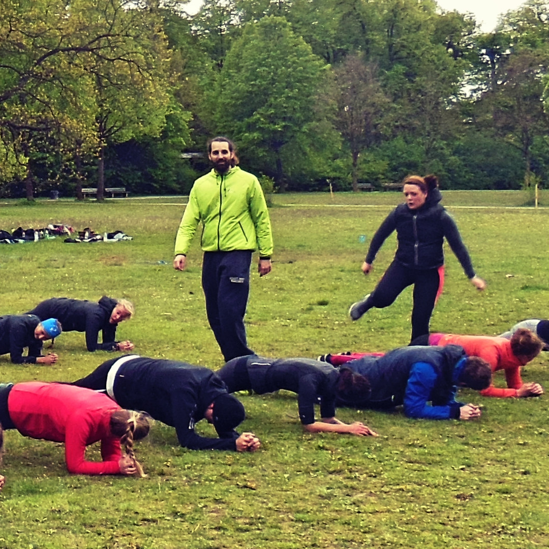 Outdoor Training in der Gruppe mit der Plank für einen flachen Bauch